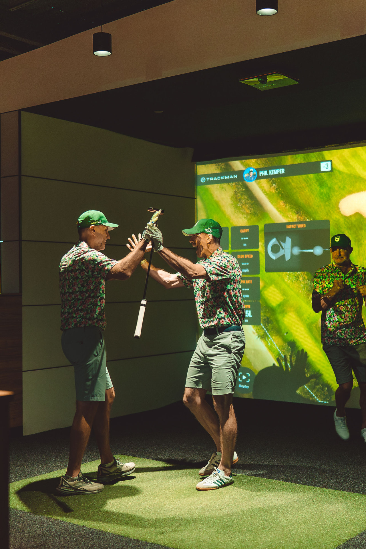 Two teammates high-fiving after a shot in a simulator bay